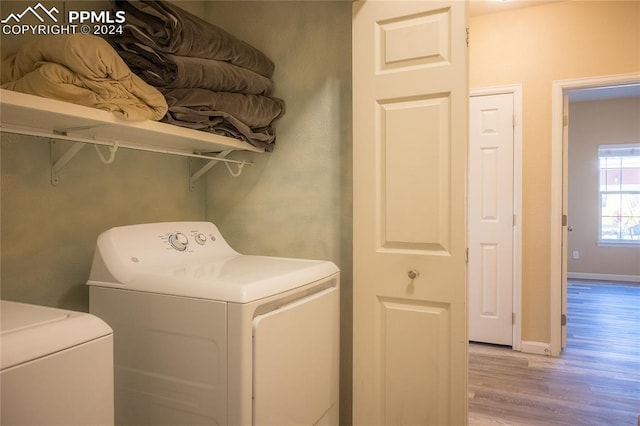 laundry room featuring washer and dryer and light hardwood / wood-style floors