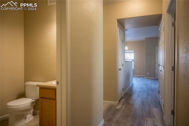 hallway with a textured ceiling and dark wood-type flooring