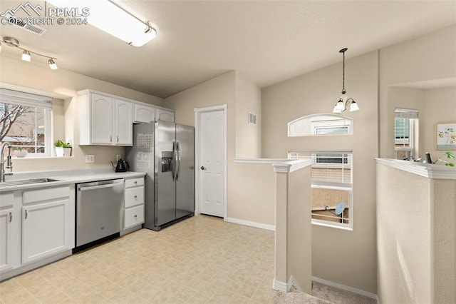 kitchen with sink, appliances with stainless steel finishes, decorative light fixtures, white cabinetry, and a chandelier