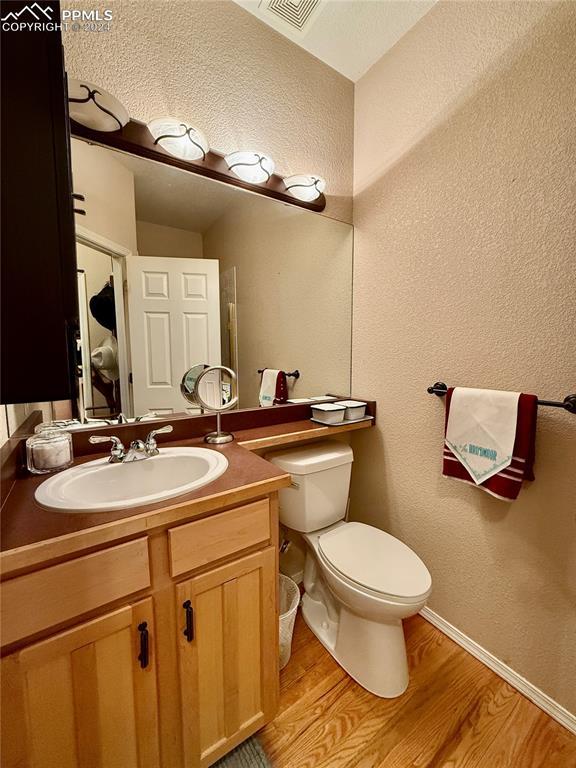 bathroom featuring hardwood / wood-style flooring, vanity, and toilet