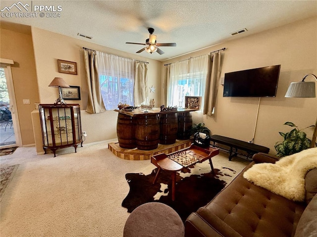 living room with light carpet, a textured ceiling, and ceiling fan