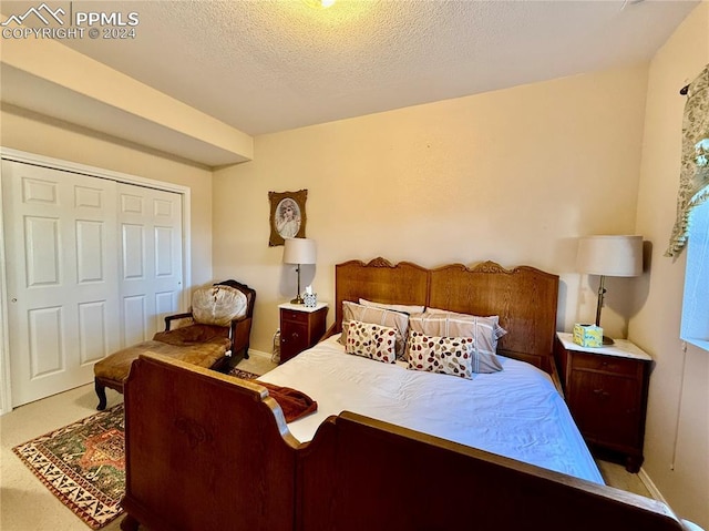 carpeted bedroom featuring a textured ceiling and a closet