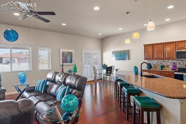 living room featuring ceiling fan, sink, and dark wood-type flooring