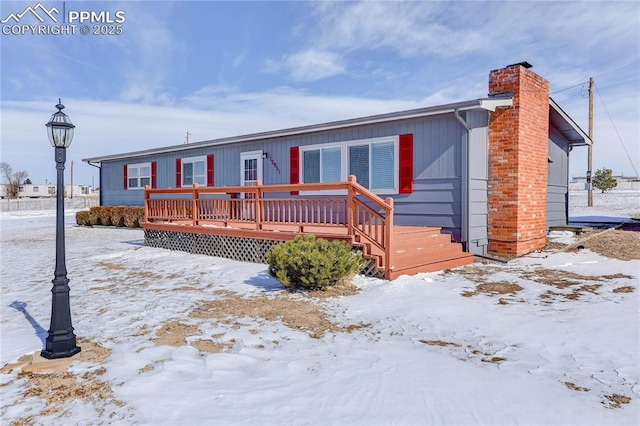 view of front of home featuring a chimney and a deck