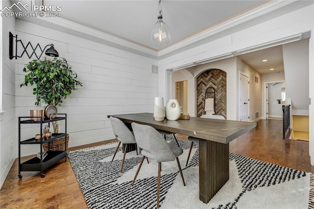 dining area with wood-type flooring and crown molding