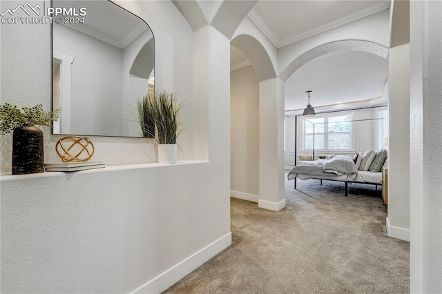 hall with light colored carpet and crown molding