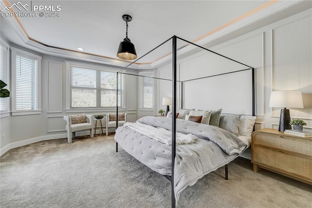 bedroom with ornamental molding, a raised ceiling, carpet floors, and multiple windows