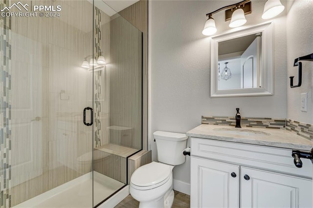 bathroom featuring an enclosed shower, vanity, and toilet