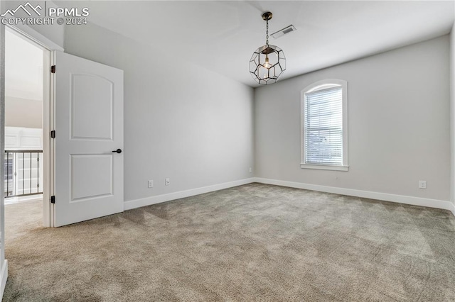 unfurnished room featuring an inviting chandelier and carpet flooring