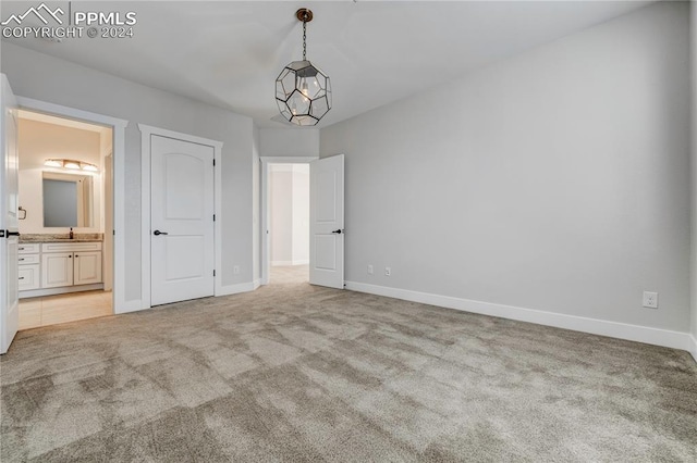 unfurnished bedroom with light carpet and connected bathroom