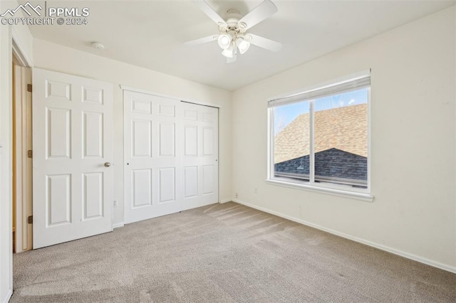 unfurnished bedroom with ceiling fan, a closet, and light colored carpet