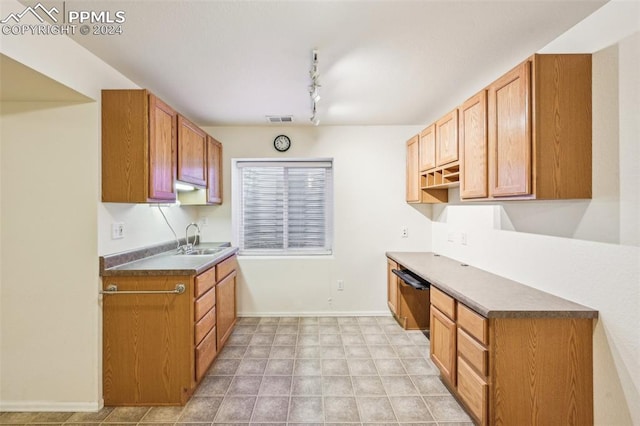 kitchen with sink, built in desk, and track lighting