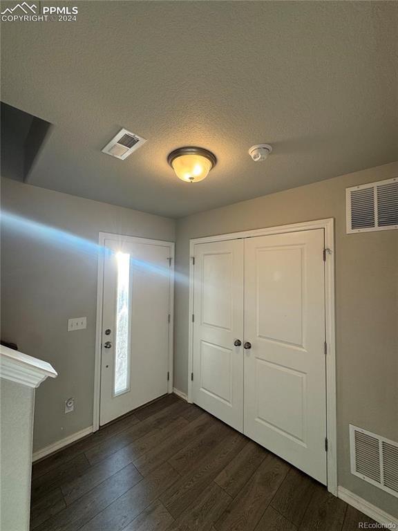 entrance foyer featuring a textured ceiling and dark hardwood / wood-style floors