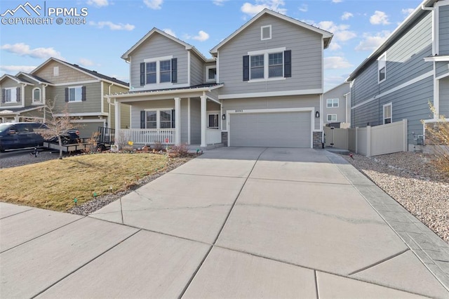 view of front of house with a front lawn, covered porch, and a garage