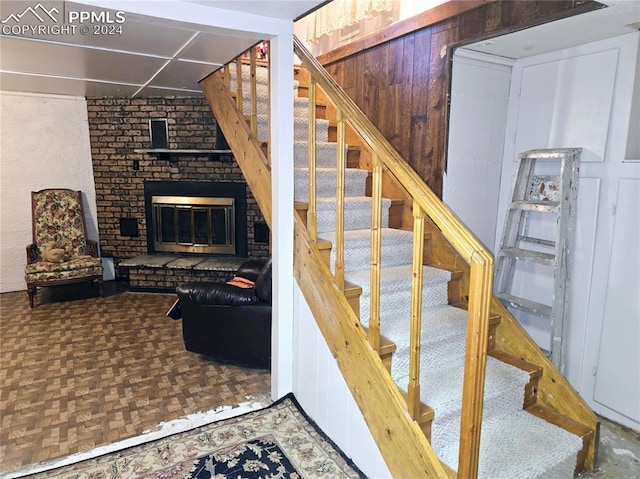 stairway featuring parquet floors and a fireplace