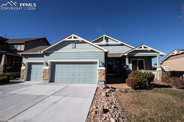 craftsman-style home featuring covered porch and a garage