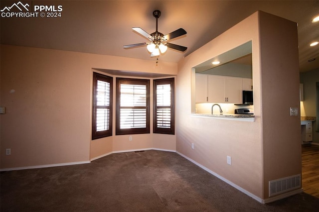 carpeted empty room with ceiling fan and sink