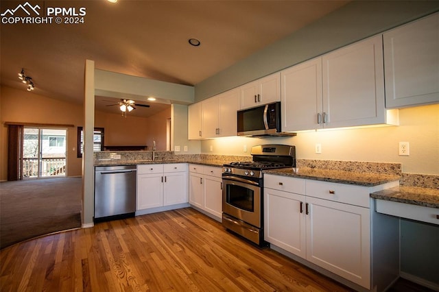 kitchen featuring lofted ceiling, sink, ceiling fan, appliances with stainless steel finishes, and white cabinetry