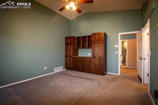 unfurnished bedroom featuring ceiling fan, light colored carpet, and high vaulted ceiling