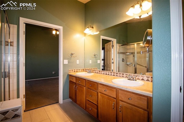 bathroom with tile patterned floors, decorative backsplash, vanity, and an enclosed shower