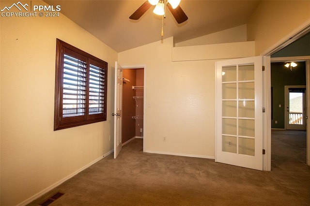 carpeted empty room with ceiling fan, french doors, and lofted ceiling