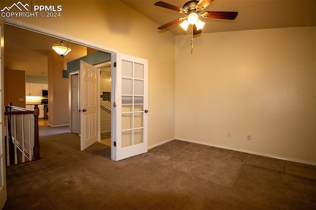 carpeted spare room featuring ceiling fan and lofted ceiling