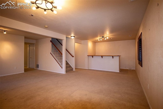 basement with carpet floors and rail lighting