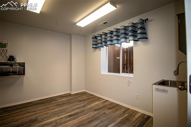 unfurnished room featuring dark hardwood / wood-style flooring and sink