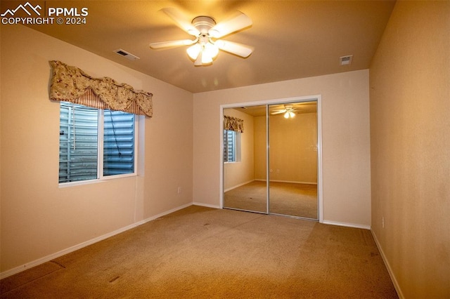 unfurnished bedroom with carpet, ceiling fan, and a closet