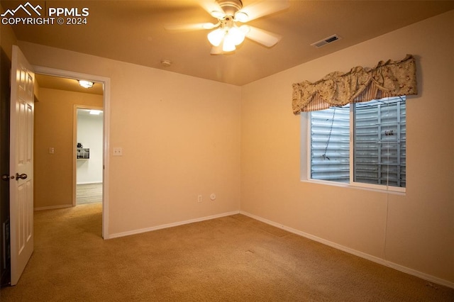 spare room featuring ceiling fan and carpet