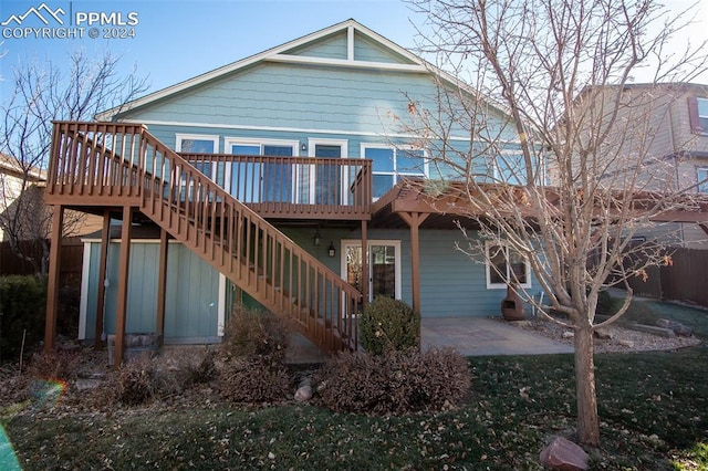 back of property featuring a patio area and a wooden deck