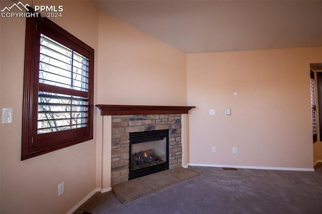 unfurnished living room featuring carpet floors, a stone fireplace, and lofted ceiling