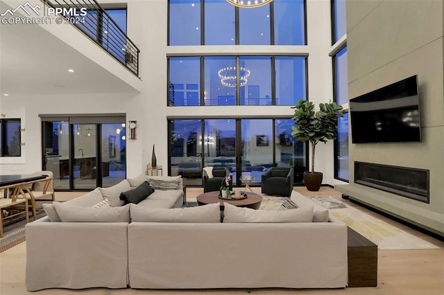 living room featuring a towering ceiling and light hardwood / wood-style flooring