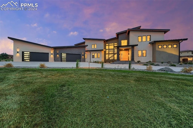 view of front of home with a yard and a garage