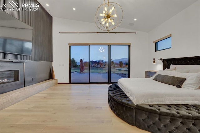 bedroom with a mountain view, lofted ceiling, access to exterior, light hardwood / wood-style floors, and a chandelier