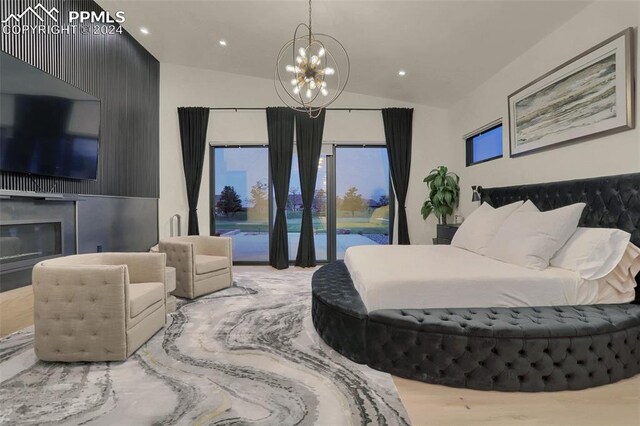 bedroom featuring hardwood / wood-style floors, a notable chandelier, access to exterior, and vaulted ceiling