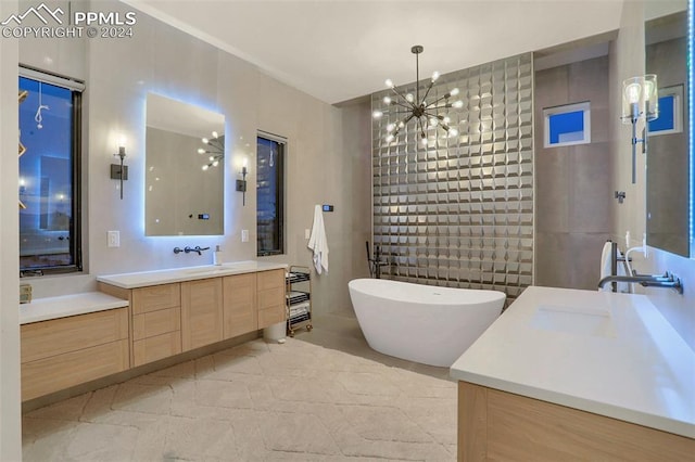 bathroom featuring a bathing tub, a notable chandelier, and vanity