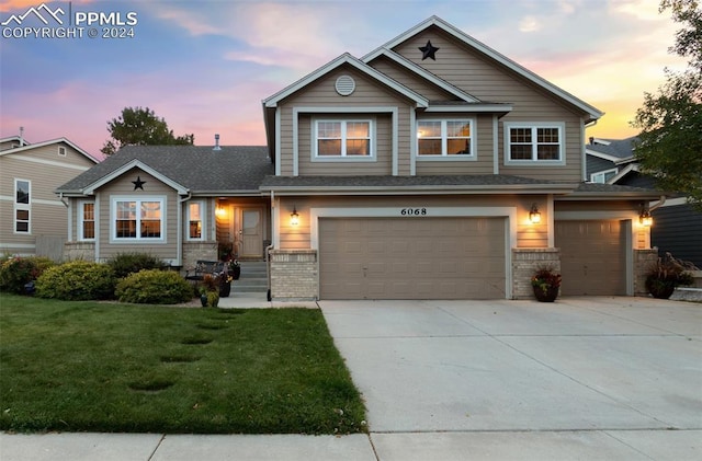 view of front of property with a garage and a lawn