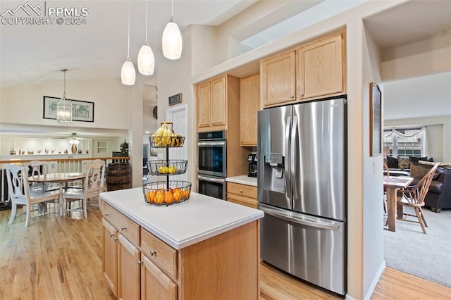 kitchen with pendant lighting, high vaulted ceiling, stainless steel appliances, and light wood-type flooring