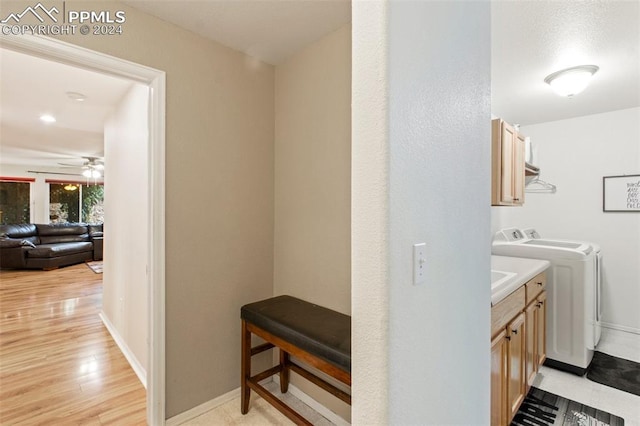 laundry room featuring washing machine and clothes dryer, cabinets, ceiling fan, and light hardwood / wood-style floors