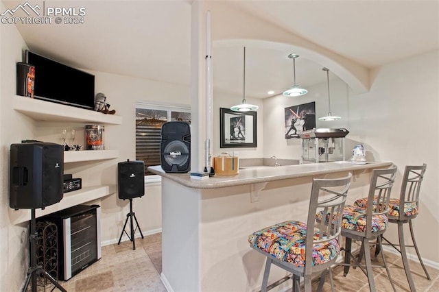 kitchen with a breakfast bar area, kitchen peninsula, and pendant lighting