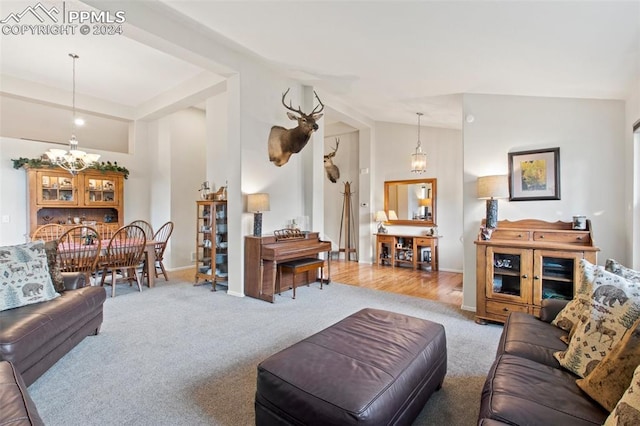 living room featuring a chandelier, hardwood / wood-style floors, and vaulted ceiling