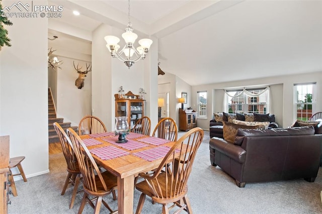 carpeted dining area featuring vaulted ceiling and a chandelier