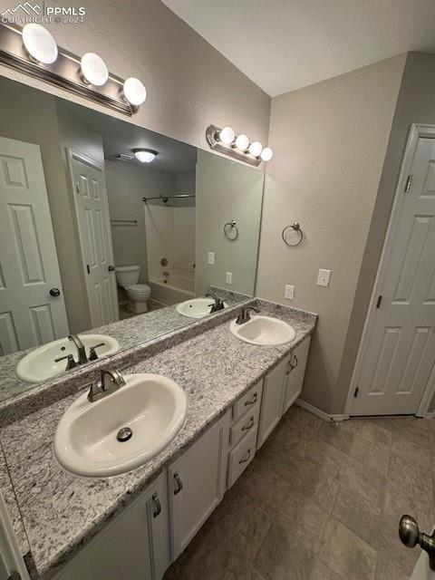 full bathroom featuring vanity, tub / shower combination, and toilet