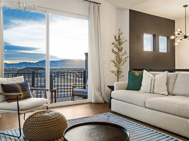 living room featuring hardwood / wood-style flooring, a mountain view, a healthy amount of sunlight, and a chandelier