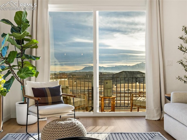 sitting room with a mountain view and wood-type flooring