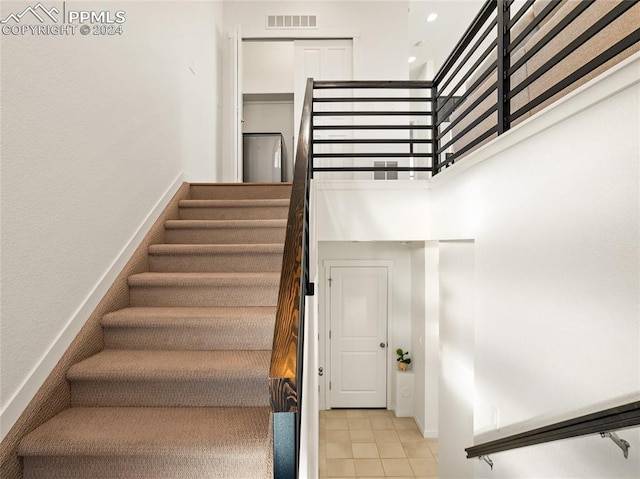 stairway with tile patterned floors