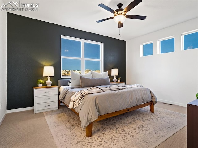 carpeted bedroom featuring ceiling fan and multiple windows