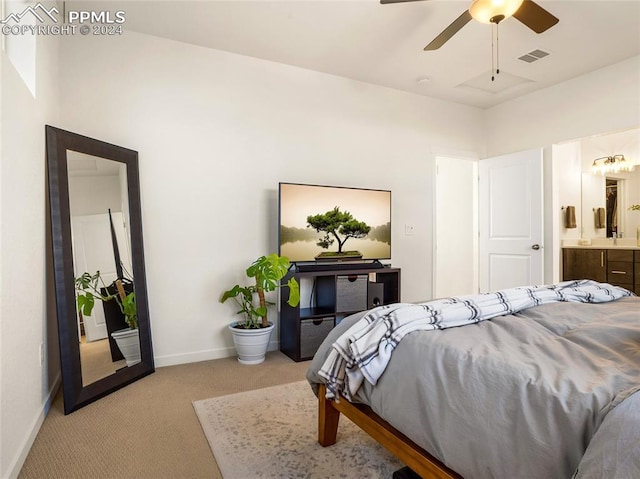 bedroom with light carpet, ensuite bath, and ceiling fan