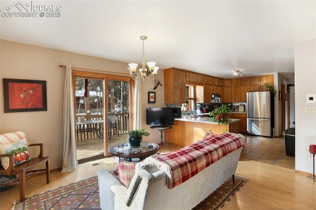living room with light hardwood / wood-style floors and a notable chandelier